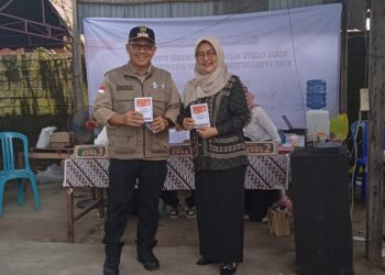 Serasi, Pj Bupati Bartim Didampingi Istri Nyoblos di TPS 01 Tamiang Layang