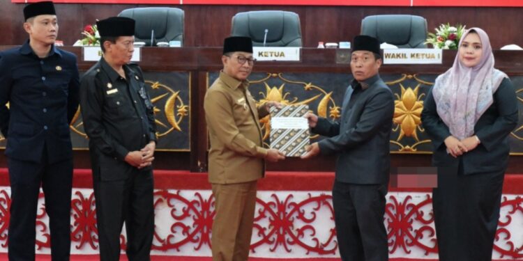 Ketua DPRD Murung Raya, Rumiadi, menerima dokumen Raperda RAPBD 2026 dari Bupati Murung Raya, Heriyus, dalam Rapat Paripurna Ke-6 Masa Sidang III di Puruk Cahu, Jumat (7/11/2025).