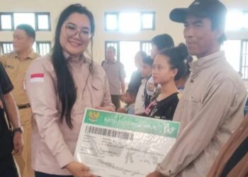 Anggota DPRD Kabupaten Kapuas, Septi Purnama Sari, menyerahkan bantuan dari BPJS Kesehatan kepada warga kurang mampu di Kecamatan Kapuas Tengah. (FOTO: IST)