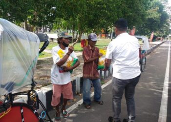 Kasatresnarkoba Polres Kapuas IPTU Budi Utomo, S.H., M.M. bersama personel saat membagikan paket sembako kepada warga di sekitar Jalan Kota Kuala Kapuas, Rabu (10/12/2025).