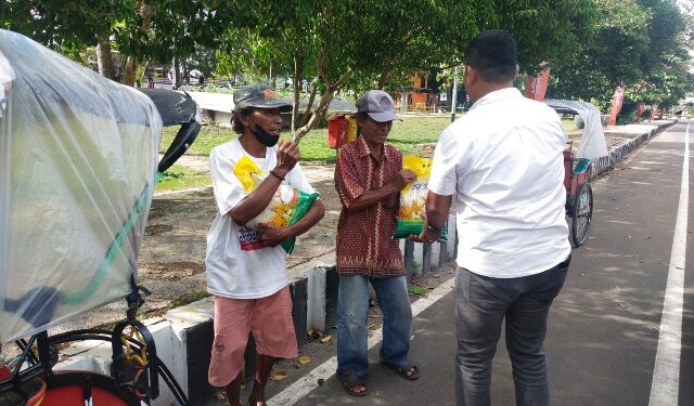 Kasatresnarkoba Polres Kapuas IPTU Budi Utomo, S.H., M.M. bersama personel saat membagikan paket sembako kepada warga di sekitar Jalan Kota Kuala Kapuas, Rabu (10/12/2025).