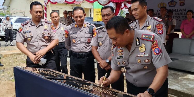 Kapolres Barito Timur AKBP Eddy Santoso saat meresmikan rumah dinas Polsek Dusun Timur dengan penandatanganan prasasti dan pemotongan pita, Kamis (18/12/2025).