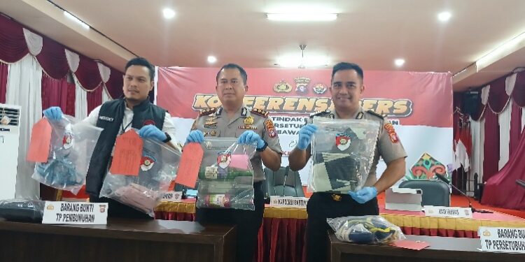Kapolres Barito Timur AKBP Eddy Santoso, S.I.K., M.H., (diapit) Kasat Reskrim AKP Hengky Prasetyo, didampingi Kasi Humas AKP Eko Sutrisno, menunjukkan barang bukti dalam press release pengungkapan kasus tindak pidana terhadap anak yang terlihat direkayasa agar terlihat seperti gantung diri, Senin (19/1/2026).
