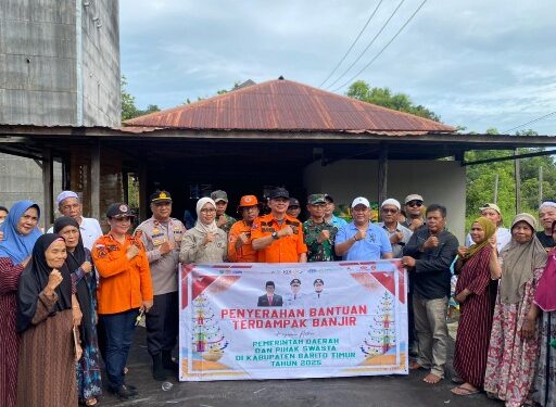 Bupati Bartim M.Yamin, beserta jajaran, berpose bersama usai menyerahkan bantuan banjir kepada warga Desa Muara Plantau, Jumat (9/1/2025).