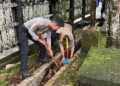 Personel Polres Bartim membersihkan selokan di Kawasan Rumah Betang Pasar Panas, Jumat (6/2/2026).