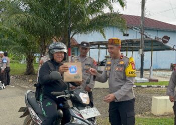 Kapolsek Patangkep IPDA Bambang Wahyudi memimpin pembagian takjil depan Mapolsek, Kamis (26/2/2026).