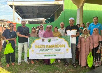 Jajaran PWI Barito Timur berpose dengan warga usai menyerahkan bantuan bahan pokok, Jumat (27/2/2026). (PWI Bartim).