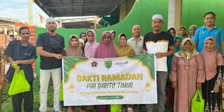 Jajaran PWI Barito Timur berpose dengan warga usai menyerahkan bantuan bahan pokok, Jumat (27/2/2026). (PWI Bartim).