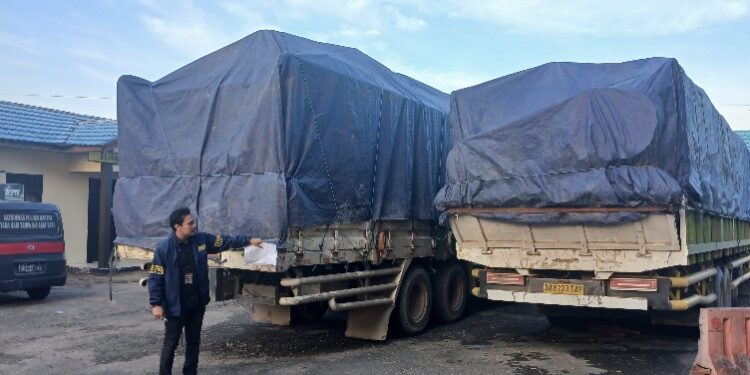 Kasatreskrim AKP Hengky Prasetyo, saat menunjukkan tiga truk yang mengangkut kayu diamankan warga.