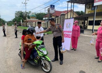 Wakapolres Bartim KOMPOL Alexander Ferdianta Sitepu, dan Kasaresnarkoba IPTU Ismail Lubis membagikan takjil Program BERLIAN kepada pengendara melintas, Senin (2/3/2026).