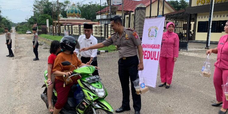 Wakapolres Bartim KOMPOL Alexander Ferdianta Sitepu, dan Kasaresnarkoba IPTU Ismail Lubis membagikan takjil Program BERLIAN kepada pengendara melintas, Senin (2/3/2026).