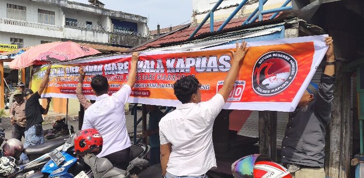 Personel Satresnarkoba Polres Kapuas yang memasang spanduk imbauan, Rabu (11/3/2026).