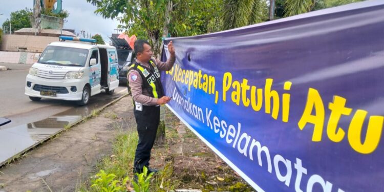 Personel Satlantas Polres Bartim, memasang spanduk imbauan keselamatan, Senin (16/3/2026).