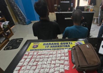 Tersangka MF alias O (36) dan SD alias A (28), beserta ratusan butir obat tanpa merek didugan narkotika yang diamankan polisi.