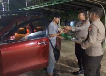 Kapolsek Dusun Timur, IPDA Sulkhan Sururi, membagikan nasi bungkus gratis kepada pemudik yang beristirahat waktu sahur, Selasa (17/3/2026) dini hari.