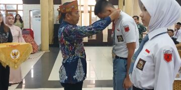 Asisten II Setda Bartim, Amrullah, mengalungkan tanda peserta seleksi Paskibraka Barito Timur, Selasa (21/4/2026).