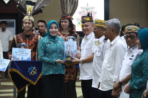 Ketua TP PKK Kalteng, Aisyah Thisia Agustiar Sabran, menyerahkan penghargaan kepada kepala daerah yang telah menyelesaikan dokumen Peta Jalan Pembangunan Kependudukan (PJPK) 2025–2029 serta penilaian kinerja stunting tahun 2025.