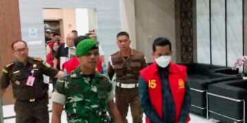 Tersangka korupsi zirkon menggunakan baju tahanan kejaksaan saat digiring menuju mobil tahanan. (Ist)
