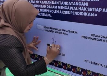 Waket I DPRD Murung Raya, Dina Maulidah, membubuhkan tanda tangan mendukung SPMB 2026-2027 di lingkup satuan pendidikan bersih pungli, Senin (4/5/2026).