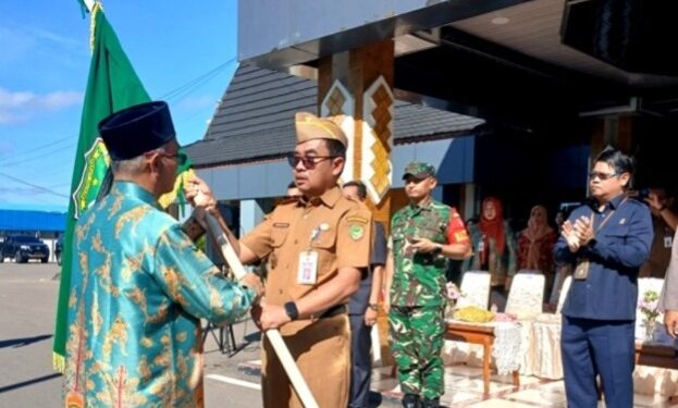 Penyerahan pataka daerah Barito Utara kepada ketua kontingen sebagai simbol kepercayaan dan tanggung jawab selama mengikuti FBIM 2026 oleh Asisten Sekretaris Daerah Bidang Pemerintahan dan Kesejahteraan Rakyat, Eveready Noor.