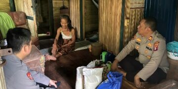 Kapolsek Awang IPTU Saipul Fazrianoor, berbincang dengan Itak Mariati, ketika menyalurkan bantuan Program Satu Hari Satu Kebaikan Polres Barito Timur, Rabu (13/6/2026).