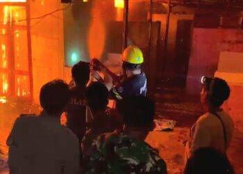 Anggota Polsek Tewah bersama tim gabungan tengah melakukan pemadaman api di Komplek Pasar Tewah. (Ist)