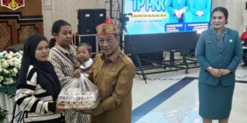 Bupati Murung Raya, Heriyus, menyerahkan bantuan kepada IRT yang memiliki balita disela Rakerda TP PKK, Senin (11/5/2206).