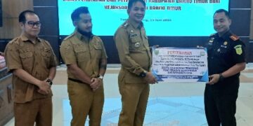 Kajari Bartim Rahmad Isnaini, menyerahkan secara simbolis aset lahan Bangi yang diterima Bupati M. Yamin, Senin (15/6/2026).