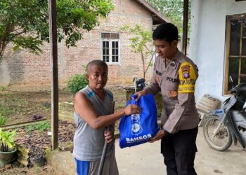 Bhabinkamtibmas Pulau Patai yang menyerahkan langsung bansos dari Polres Barito Timur, Jumat (12/6/2026).