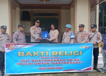 Kapolsek Dusun Timur, IPDA Sulkhan Sururi, menyerahkan bantuan sosial yang diterima koster atau penjaga GKE Yakin, Jumat (19/6/2026).