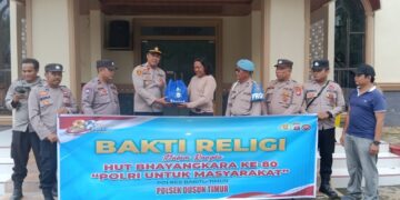 Kapolsek Dusun Timur, IPDA Sulkhan Sururi, menyerahkan bantuan sosial yang diterima koster atau penjaga GKE Yakin, Jumat (19/6/2026).