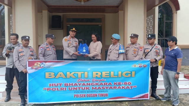Kapolsek Dusun Timur, IPDA Sulkhan Sururi, menyerahkan bantuan sosial yang diterima koster atau penjaga GKE Yakin, Jumat (19/6/2026).