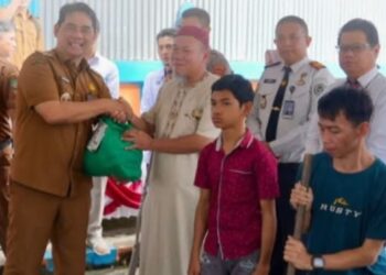 Bupati Barito Utara, H. Shalahuddin, menyerahkan bansos.