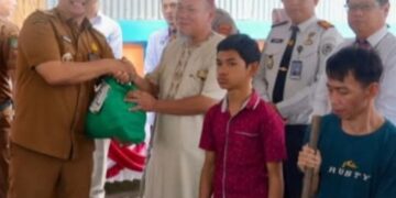 Bupati Barito Utara, H. Shalahuddin, menyerahkan bansos.