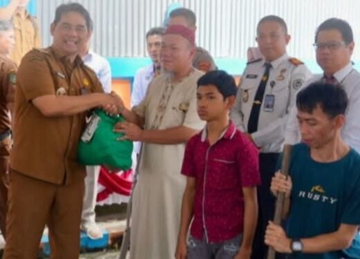 Bupati Barito Utara, H. Shalahuddin, menyerahkan bansos.