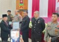 Ketua DPRD Kabupaten Murung Raya, Rumiadi, menyerahkan penghargaan pada momen Hari Bhayangkara ke-80.