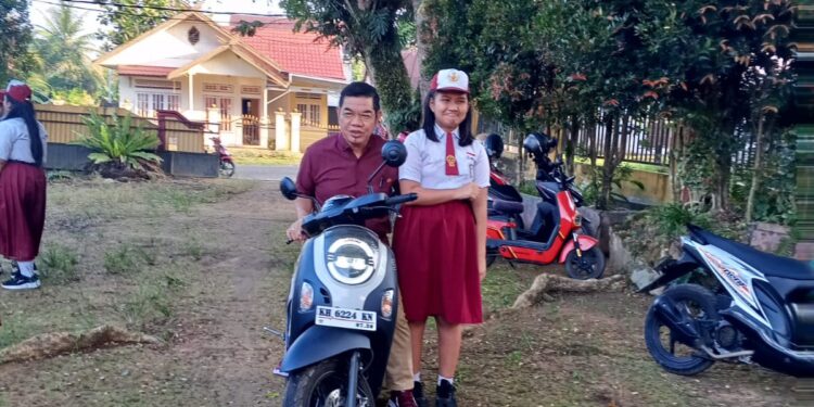 Anggota DPRD Kalimantan Tengah, Ampera AY Mebas, ketika mengantar putrinya hari pertama masuk sekolah, Senin (13/7/2026).