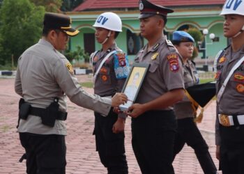 Kapolres Gunung Mas AKBP Heru Eko Wibowo, S.I.K., M.H., mencoret foto personel sebagai simbol pemecatan. Kegiatan tersebut disaksikan seluruh pejabat utama, personel, dan ASN Polres Gunung Mas, digelar di Lapangan Tantya Sudhirajati, Selasa (14/7/2026). (Ist)