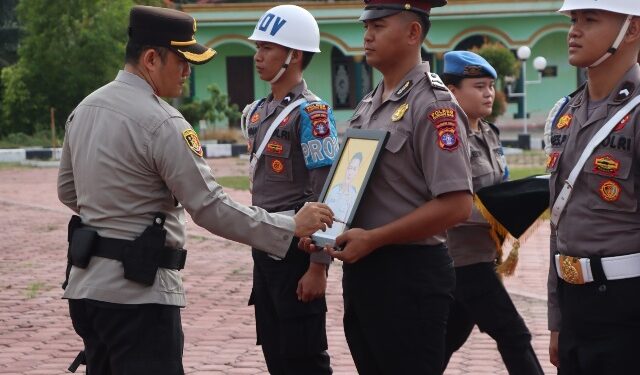 Kapolres Gunung Mas AKBP Heru Eko Wibowo, S.I.K., M.H., mencoret foto personel sebagai simbol pemecatan. Kegiatan tersebut disaksikan seluruh pejabat utama, personel, dan ASN Polres Gunung Mas, digelar di Lapangan Tantya Sudhirajati, Selasa (14/7/2026). (Ist)