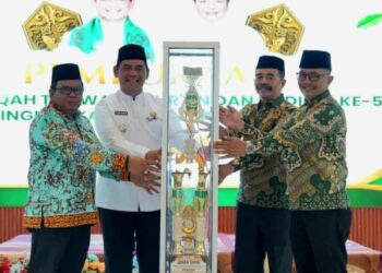 Bupati Barito Utara, H. Shalahuddin, menyerahkan trofi bergilir kepada Ketua Panitia sebagai simbol dimulainya pelaksanaan MTQH ke-53, Sabtu (25/7/2026).