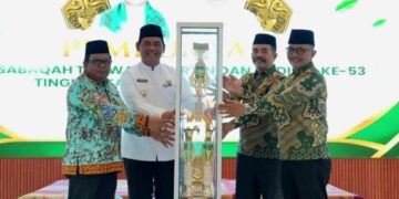 Bupati Barito Utara, H. Shalahuddin, menyerahkan trofi bergilir kepada Ketua Panitia sebagai simbol dimulainya pelaksanaan MTQH ke-53, Sabtu (25/7/2026).