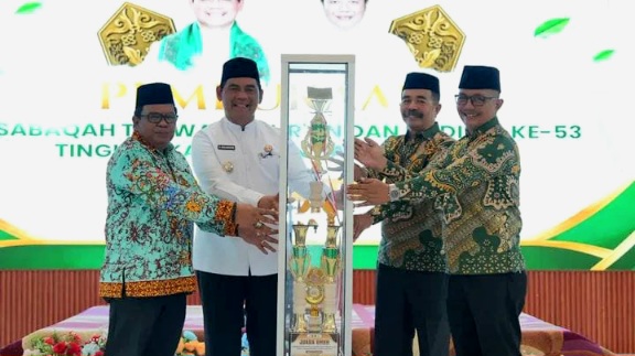 Bupati Barito Utara, H. Shalahuddin, menyerahkan trofi bergilir kepada Ketua Panitia sebagai simbol dimulainya pelaksanaan MTQH ke-53, Sabtu (25/7/2026).