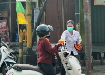 Petugas Dinas Kesehatan Bartim membagikan masker kepada pengendara yang melintas di pertigaan Jalan A. Yani - Nansarunai Tamiang Layang, Rabu (19/8/2026).