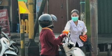 Petugas Dinas Kesehatan Bartim membagikan masker kepada pengendara yang melintas di pertigaan Jalan A. Yani - Nansarunai Tamiang Layang, Rabu (19/8/2026).