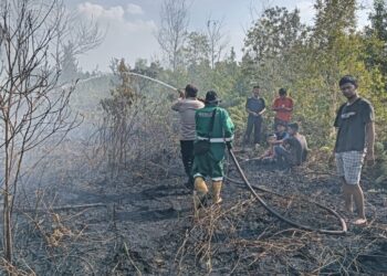 Personel Polsek Sebangau dan TSAK memadamkan lahan yang terbakar. (ist)