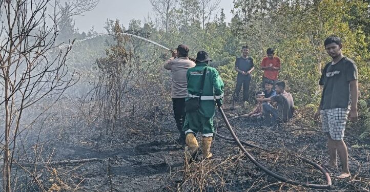 Personel Polsek Sebangau dan TSAK memadamkan lahan yang terbakar. (ist)