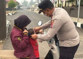 Kapolsek Dusun Timur, IPDA Sulkhan Sururi, S.E., yang secara langsung memasangkam masker ke penumpang pengendara roda dua, Senin (31/8/2026).