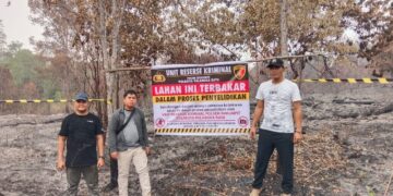 Unit Reskrim Polsek Rakumpit memasang police line di areal yang sebelumnya terbakar di Jalan Tumbang Talaken Km 78, Kelurahan Bukit Sua, Kecamatan Rakumpit, Rabu (2/9/2026).