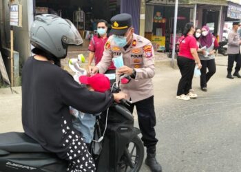 Kapolsek Dusun Tengah IPTU Stefanus Rantealo, S.H., M.M., secara langsung memasangkan masker untuk anak dari pengendara yang melintas, Sabtu (5/9/2026).