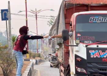 Para perawat yang tergabung dalam PPNI Barito Timur, membagikan masker gratis kepada pengendara, Sabtu (5/9/2026).
